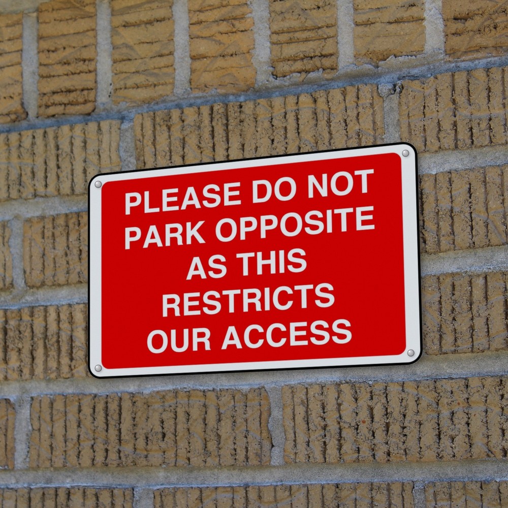 Please Do Not Park Opposite as This Restricts Our Access sign in use